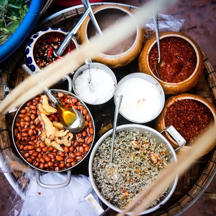 Một tô cơm hến Huế truyền thống với đầy đủ các nguyên liệu như hến xào, rau sống, đậu phộng, tóp mỡ và nước hến