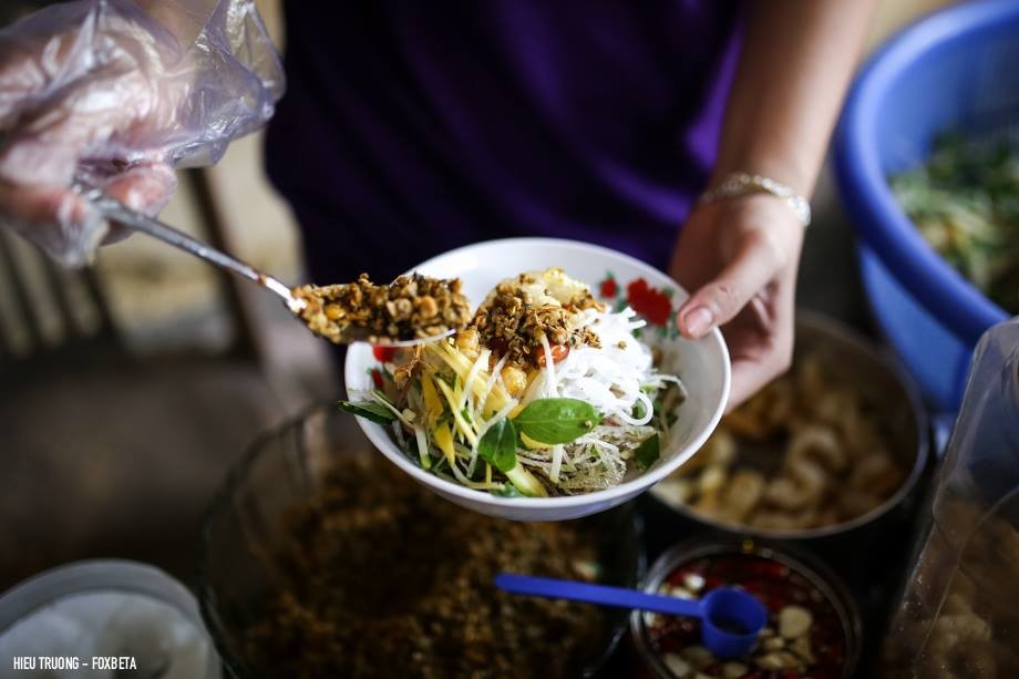 Khám Phá Cơm Hến Huế: Nét Dân Dã, Tinh Hoa Ẩm Thực Cố Đô 7 Bát bún hến Huế khô với hến xào, rau sống tươi xanh và các loại gia vị hấp dẫn