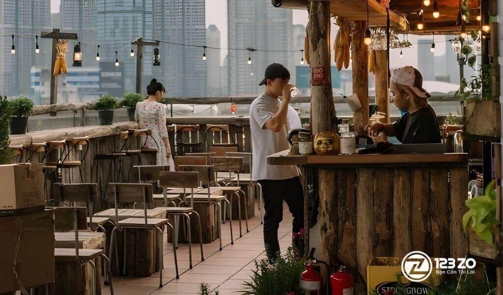 Top 4 Quán Rooftop Nổi Tiếng Tại Quận Phú Nhuận View Đỉnh Cho Tín Đồ Sống Ảo 7 Quán rooftop tại Quận Phú Nhuận bằng gỗ mộc mạc tại Ráng Chiều Rooftop, phía sau là khung cảnh các tòa nhà cao tầng của thành phố.