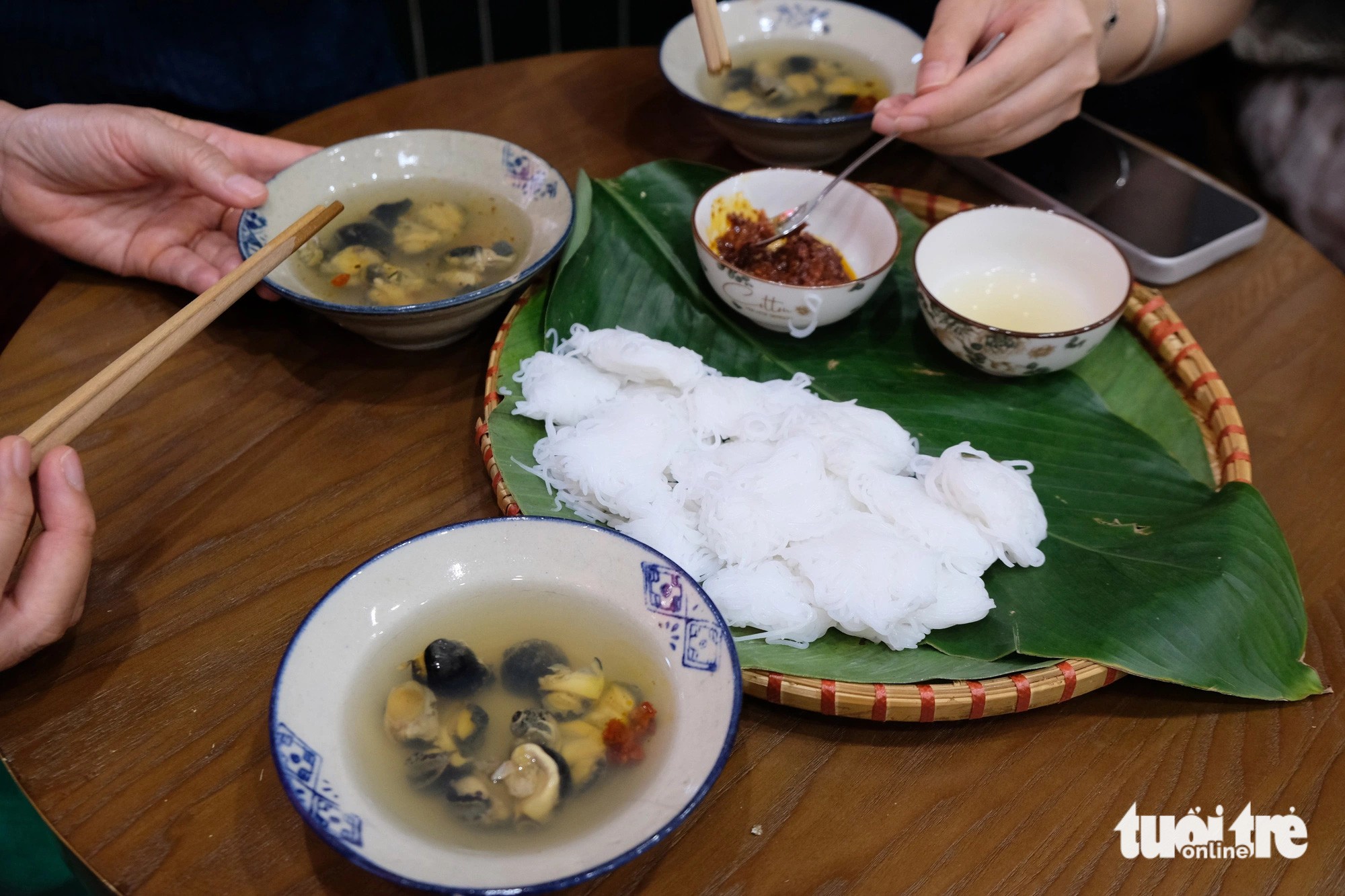 Bát bún ốc nguội chuẩn vị Hà Nội với màu ánh đỏ vàng dịu nhẹ sau khi thêm nước màu ớt chưng