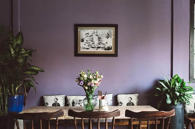 Quán Bụi Ngô Văn Năm: Nơi Vị Giác Gặp Gỡ Ký Ức Ẩm Thực Việt Giữa Lòng Sài Gòn 9 Không gian nội thất Quán Bụi mang phong cách Indochine với bàn ghế gỗ và tranh tường cổ điển