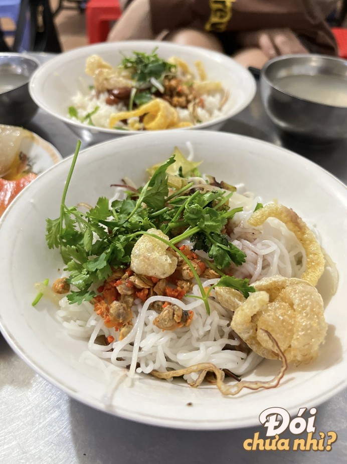 Cơm hến đầy đặn với các loại topping và rau sống