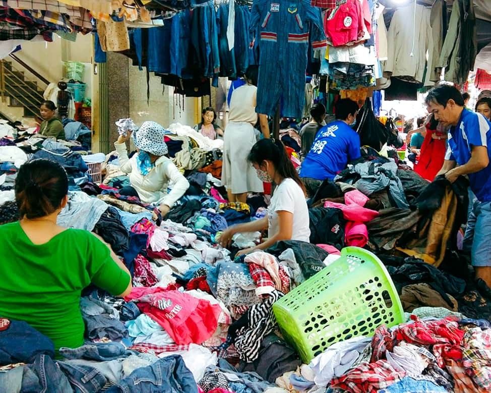 Khám Phá Top 10 Chợ Đồ Cũ Sài Gòn: Thiên Đường Săn Đồ Độc Lạ, Giá Rẻ 12 Khách hàng đang lựa chọn quần áo đồ si tại chợ Hoàng Hoa Thám