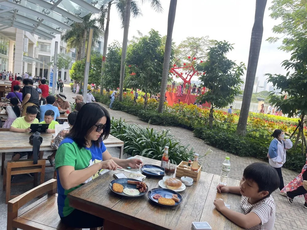 Phố Ẩm Thực Đêm Sky Garden: Điểm Nhấn Cao Cấp Cho Kinh Tế Ban Đêm Quận 7 5 Khách hàng đang thưởng thức các món ăn ngon tại một khu vực ẩm thực