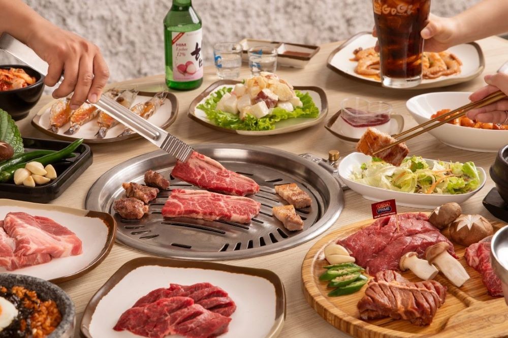 Khám Phá Top 10 Quán Buffet Quận 5 Ngon Khó Cưỡng, Ăn Là Ghiền! 13 Thực khách đang nướng thịt tại nhà hàng GoGi House Hùng Vương Plaza