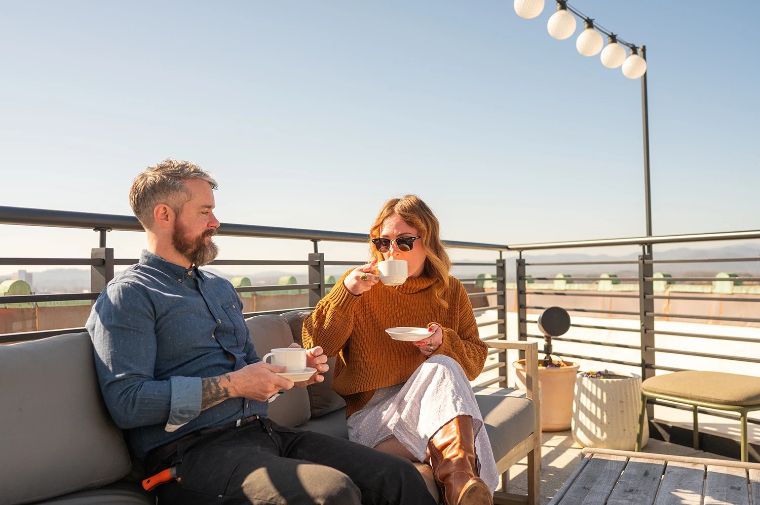 Một cặp đôi đang thưởng thức cà phê và ngắm nhìn quang cảnh từ sân thượng The Flat Iron Rooftop