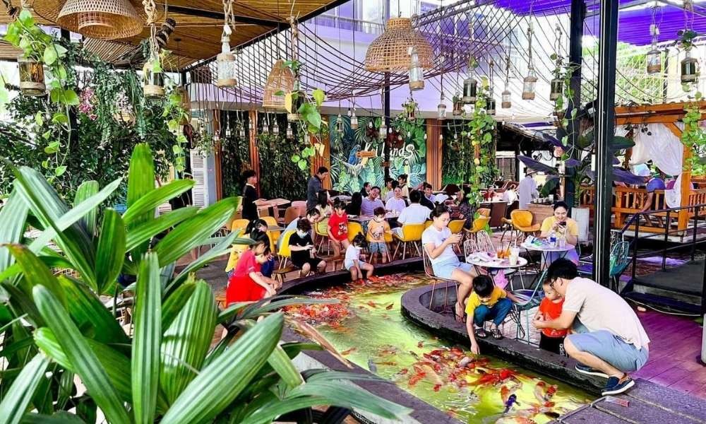 Không gian quán cà phê cá Koi Koilands Coffee với hồ cá lớn và nhiều cây xanh