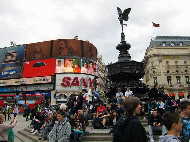 Những tòa nhà cổ kính và dòng xe cộ tấp nập tại Piccadilly Circus với ánh đèn neon rực rỡ